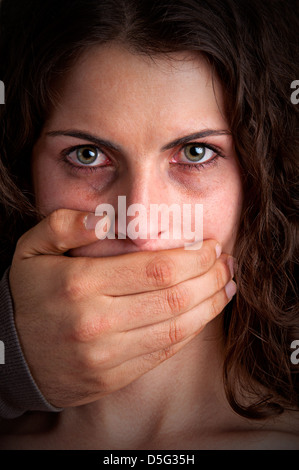 Nahaufnahme von einem mans Hand den Mund zu einem Womans. Konzept von häuslicher Gewalt oder Entführung. Düstere Stimmung. Stockfoto
