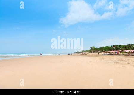 Breiten Sandstrand mit Touristen, Regenschirme und Betten. Die fünf Kilometer lange Sandstrand erstrecken sich von Kuta, Bali, Indonesien. Stockfoto