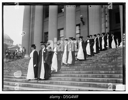 Dieses Foto aus dem Jahr 1913 zeigt eine Abschlussfeier am Barnard College, bei der Studentinnen in weißen Kleidern, Mortarboards und Gewändern gezeigt werden. Das Bild zeigt die akademische Prozession, bei der Studenten die Stufen des Colleges hinaufgehen und symbolisieren die Errungenschaften der Bildung und des Aufstiegs der Frauen in der Wissenschaft während des frühen 20. Jahrhunderts. Stockfoto