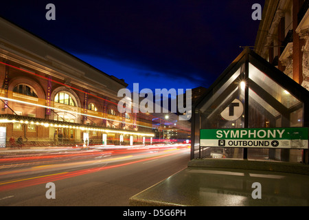 Boston Mbta Symphonie u-Bahn-Haltestelle mit historischen Symphony Hall Straßenseite mit beweglichen Ampeln nachts verschwommen Stockfoto