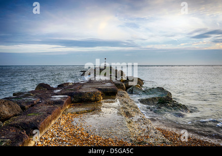 Eine lange Meer Buhne mit Leuchtturm am Strand von Hengistbury Head in der Nähe von Bournemouth in Dorset. Stockfoto