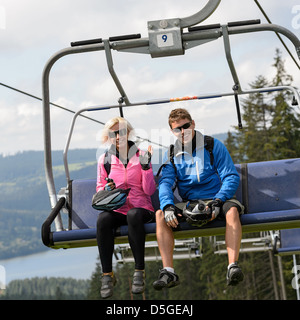 Junge lächelnde paar sitzt am Sessellift Stockfoto