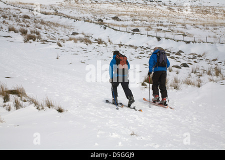 Conwy in Wales März zwei fit gesunde Männer Langlaufen entlang einer schneebedeckten Titel übung Snowdonia National Park Stockfoto