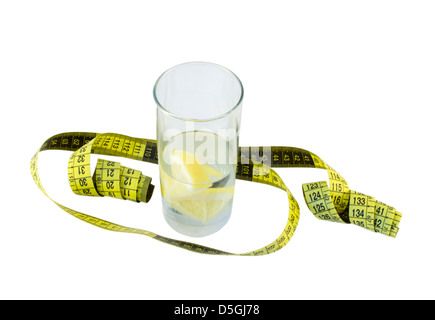 Quellwasser mit Zitrone und einem Glas gelb Zentimeter um das Glas isoliert auf weißem Hintergrund Stockfoto