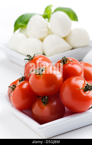 Mozzarella, Tomaten und frischem Basilikum Blätter auf weißem Hintergrund Stockfoto