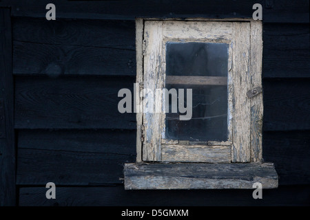 Alten verwitterten lackierten Fensterrahmen in einer hölzernen Scheune. Farbe abblättert. Stockfoto