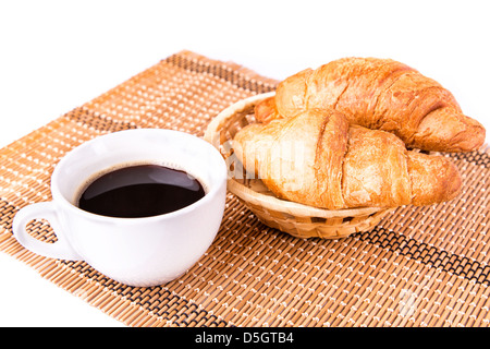 Frische und leckere französische Croissants in ein Korb und eine Tasse Kaffee serviert isolierten auf weißen Hintergrund Stockfoto