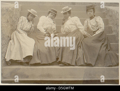 Ein Foto aus dem Jahr 1900, das vier afroamerikanische Frauen auf den Stufen eines Gebäudes der Atlanta University in Georgia zeigt. Das Bild repräsentiert das afroamerikanische Leben um die Jahrhundertwende. Stockfoto
