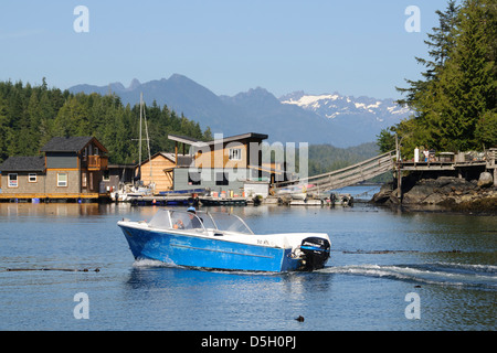 Vancouver Island, Tofino. Motorboot vorbei schwimmende Häuser. Berge der Strathcona Provincial Park im Hintergrund. Stockfoto