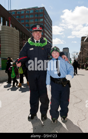 Polizist und junge Junge verkleidet als Polizist bei der St. Patricks Day Parade in Montreal, Québec, Kanada. Stockfoto