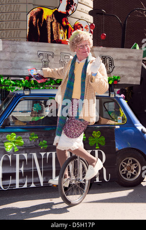 Männliche Einradfahrer verkleidete sich als eine ältere Frau bei der St. Patricks Day Parade in Montreal, Québec, Kanada. Stockfoto