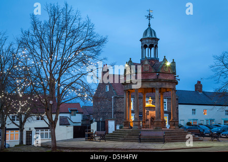 Der Market Cross und die Pumpe im St James Square Boroughbridge, North Yorkshire. Stockfoto