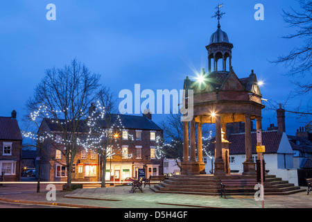 Der Market Cross und die Pumpe im St James Square Boroughbridge, North Yorkshire. Stockfoto