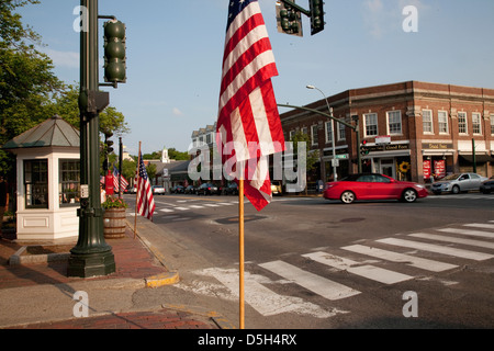 Amerikanische Flaggen mit roten Auto fahren vor Schaufenster von Lexington, MA am Memorial Day 2011 Stockfoto