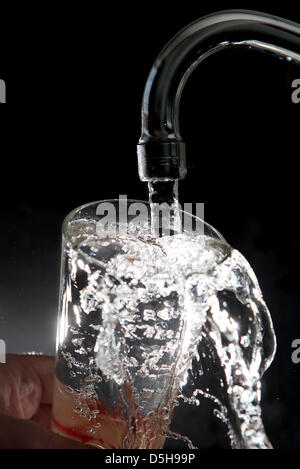 Datei - läuft Wasser aus einem Wasserhahn in ein Glas in Köln, Deutschland, datiert 17. August 2009. Teil unseres Trinkwassers kommt direkt aus dem Grundwasser tief in der Erde. Foto: Oliver Berg Stockfoto