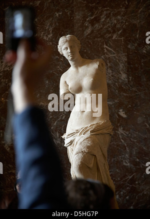 Venus von Milo, Aphrodite-Statue im Louvre mit einem touristischen Arm und Hand mit dem Fotografieren Stockfoto