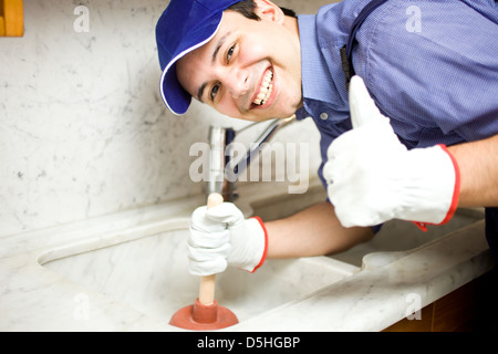 Porträt eines lächelnden Klempners mit einem Kolben Stockfoto