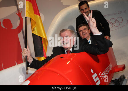 Bayerns Ministerpräsident Horst Seehofer (L-R), DOSB (Deutscher Olympischer Sportverband) Präsident Thomas Bach und ehemaligen deutschen Rennrodel Athlet Georg Hackl posieren in einen Bob im deutschen Haus bei den Olympischen Winterspielen in Vancouver, Kanada, 19. Februar 2010. Foto: Daniel Karmann Stockfoto