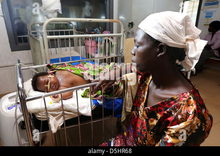 Mutter schaut ihr krankes Baby in einem Krankenhaus in Techiman, Ghana Stockfoto