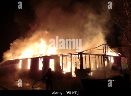 HANDOUT - Feuerwehrleute löschen einen Brand in ein Asyl suchender Schutz in Ellhofen, Deutschland, in der Nacht vom 18. zum 19. September 2012. 17 Personen wurden in der hölzernen Baracke untergebracht. Sie wurden in ein anderes Tierheim verschoben. Sechs Asylbewerber und zwei Feuerwehrleute wurden leicht verletzt. Das Feuer verursachte Schäden von 100.000 Euro. Foto: FEUERWEHR ELLHOFEN Stockfoto