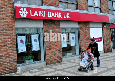 Eine Frau mit einem Kinderwagen geht es vorbei an eine Filiale der Laiki Bank in Nord-London, England, Vereinigtes Königreich. Stockfoto