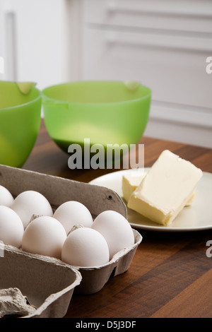 Backzutaten auf Tisch: Eiern, Butter und Mehl Stockfoto