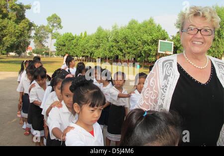 Gerlinde Engel abgebildet ist mit ihren Schülern in der Schule im Dorf Sikeud, Laos, 5. November 2012. Bürsten Zähne und Sport am Morgen sind Bestandteile des täglichen Ritual in der Schule, wo Gerlinde Engel ein strenges Regiment führt. Engel verwendet zum starten und verwalten Textilfabriken auf der ganzen Welt seit Jahren. Ihre letzte Station war in Laos, wo sie jetzt beschlossen hat, zu bleiben und fand eine s Stockfoto