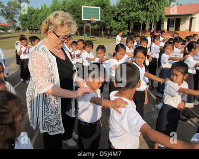 Gerlinde Engel abgebildet ist mit ihren Schülern in der Schule im Dorf Sikeud, Laos, 5. November 2012. Bürsten Zähne und Sport am Morgen sind Bestandteile des täglichen Ritual in der Schule, wo Gerlinde Engel ein strenges Regiment führt. Engel verwendet zum starten und verwalten Textilfabriken auf der ganzen Welt seit Jahren. Ihre letzte Station war in Laos, wo sie jetzt beschlossen hat, zu bleiben und fand eine s Stockfoto