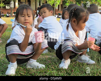 Schülerinnen und Schüler der Gerlinde Engels Schule sind im Dorf Sikeud, Laos, 5. November 2012 abgebildet. Bürsten Zähne und Sport am Morgen sind Bestandteile des täglichen Ritual in der Schule, wo Gerlinde Engel ein strenges Regiment führt. Engel verwendet zum starten und verwalten Textilfabriken auf der ganzen Welt seit Jahren. Ihre letzte Station war in Laos, wo sie jetzt beschlossen hat, zu bleiben und eine Schule. Sie Stockfoto