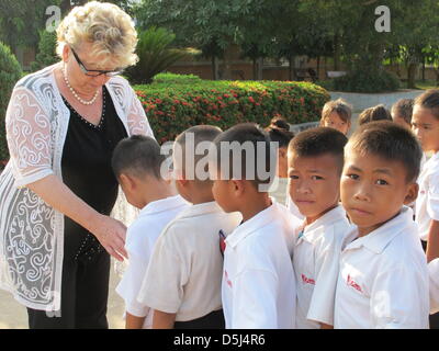 Gerlinde Engel abgebildet ist mit Schülerinnen und Schülern an einer Schule in Sikeud, Laos, 5. November 2012. Engel gegründet und geleitet von Textilfabriken auf der ganzen Welt seit vielen Jahren. In diesen Tagen, Gerlinde Engel lebt in Laos und betreut mehr als 1000 Kinder an der Schule in Sikeud. Foto: Christiane Oelrich Stockfoto