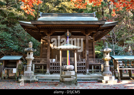 Tokkoin Tempel, Buddhist, im Wald bei Kobe, Japan. Kleine Holzhalle, frankiert von 2 Steinlaternen und im Vordergrund Holz und Stein Räuchergefäß. Stockfoto