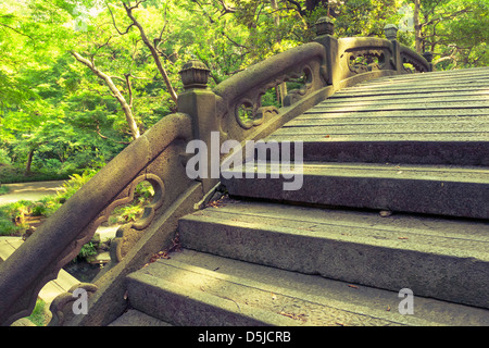 Stein bucklige Brücke Fragment mit einem geschnitzten Geländer im japanischen Zen-Garten Stockfoto