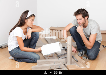 Junge interracial paar Montage Bett Möbel mit Problemen und Schwierigkeiten im neuen Zuhause Stockfoto