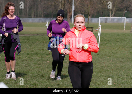 Eine Gruppe von Läufern in einem 5km in einem Londoner Park teilnehmen. Es ist eine weltweite Organisation namens Parkrun gefördert. Stockfoto