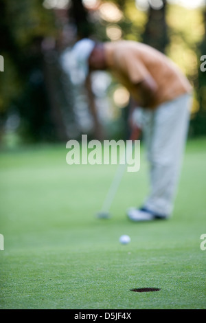 Golfer setzen, selektiven Fokus auf Loch vorne Stockfoto