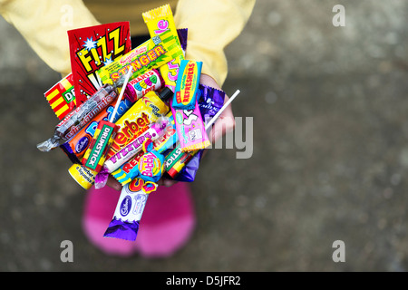 Mädchen-Hände halten verschiedene Kinder Retro-Süßigkeiten und Bonbons Stockfoto