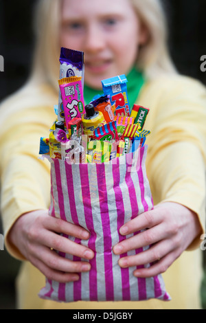 Mädchen hält einen Beutel mit sortierten Kinder Retro-Süßigkeiten und Bonbons Stockfoto