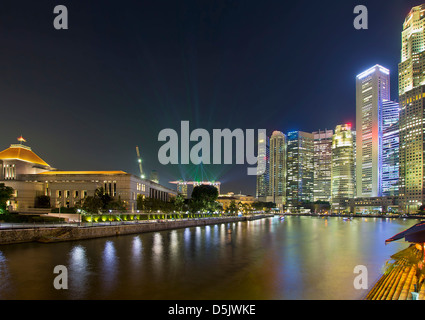 Skyline von Singapur Central Business District (CBD) von Boat Quay am Singapore River in der Nacht mit Laser-Licht-Show Stockfoto
