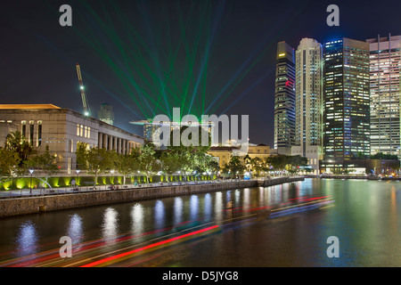 Skyline von Singapur Central Business District (CBD) von Boat Quay am Singapore River mit Laser-Licht-Show in der Nacht Stockfoto