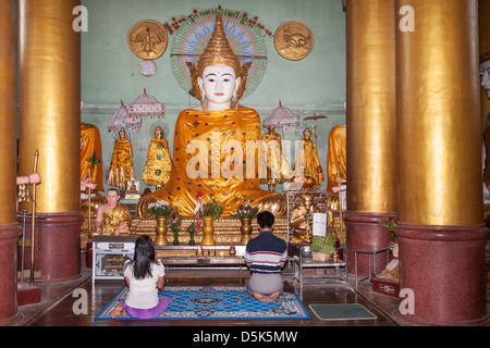 Gläubige beten im Inneren einen Betsaal an der Shwedagon-Pagode, Yangon (Rangoon), Myanmar (Burma) Stockfoto