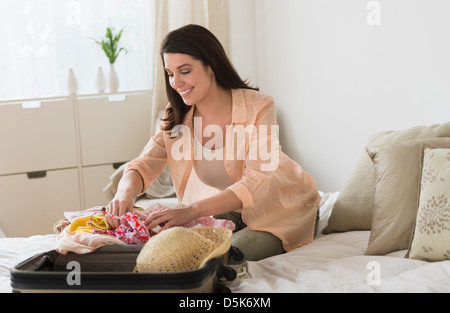 Frau packen Koffer im Schlafzimmer Stockfoto