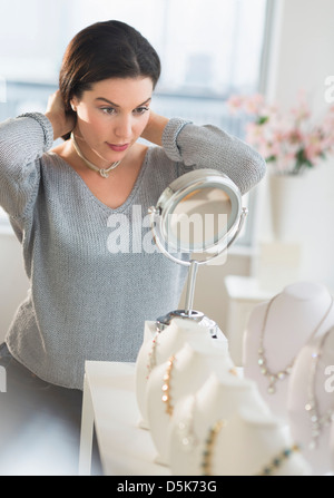 Frau versucht auf Halskette Stockfoto