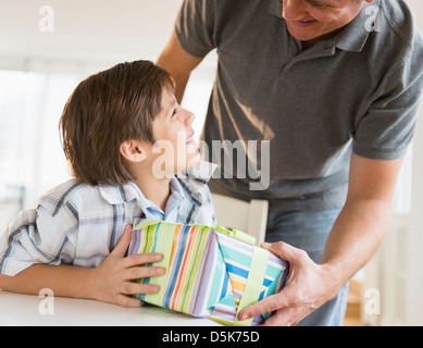 Jungen (8-9) empfangende Geschenk des Vaters Stockfoto