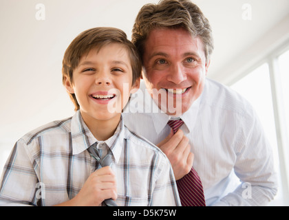 Vater und Sohn (8-9) Anpassung Krawatten Stockfoto