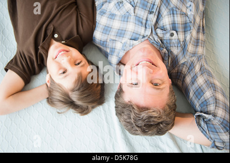 Vater und Sohn (8-9) auf Bett liegend Stockfoto