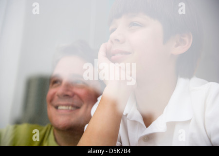 USA, New Jersey, Jersey City, Sohn (8-9) und Vater Blick durch Fenster Stockfoto