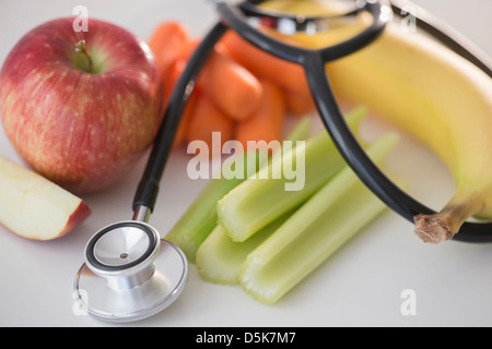 Studioaufnahme von Stethoskop mit Obst und Gemüse Stockfoto