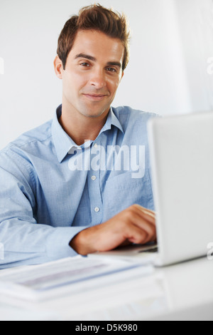 Porträt von Mitte erwachsener Mann am Schreibtisch Stockfoto