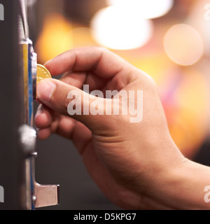 Hand, die Münze in die Maschine einlegen Stockfoto