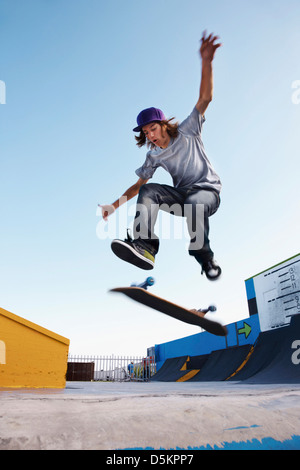 Junger Mann auf Skateboard springen Stockfoto